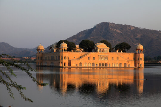 Jal Mahal reflected in the tranquil waters of Man Sagar Lake during golden hour in Jaipur, Rajasthan, India