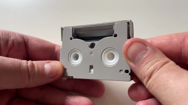 Hands Holding MiniDV Videotape Cassette Close Up