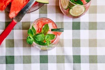 Summer refreshing watermelon drink with ice, mint and slices of lime on the table. Fresh healthy cold melon beverage. Fruit infused water, herbs and lemon. © Caterina Trimarchi