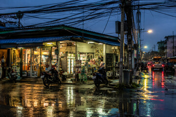 Fototapeta premium Wet street night shop motorcycle reflection urban rain electric wire city moody