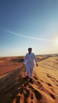 Authentic Journey: Arab Businessman Walks Desert Dune, Dubai Sunset