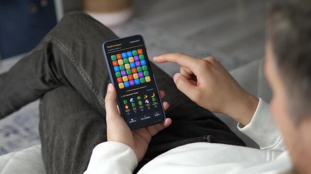 Mobile gaming experience with colorful puzzle mechanics highlights the growth of casual entertainment, interactive technology and digital leisure in modern everyday life.
