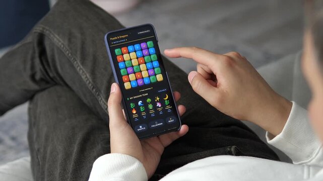 Mobile gaming experience on smartphone with colorful puzzle gameplay, highlighting the growth of casual games, digital entertainment and interactive technology trends.