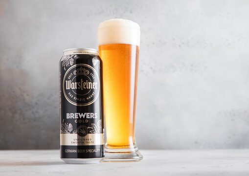 LONDON,UK - MARCH 02, 2026: Glass of cold Warsteiner brewers gold lager beer and aluminium can on light table background.
