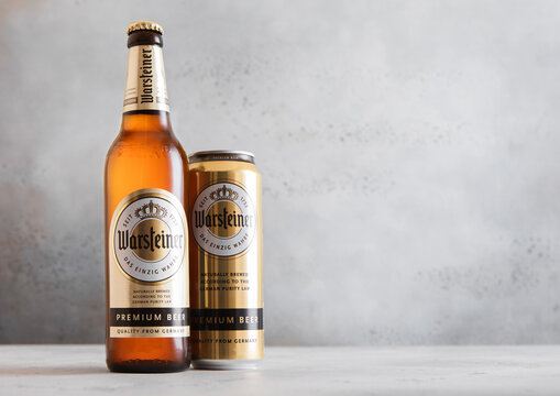 LONDON,UK - APRIL 12, 2026: Bottle and tin of Warsteiner brewers gold lager beer on light table background.
