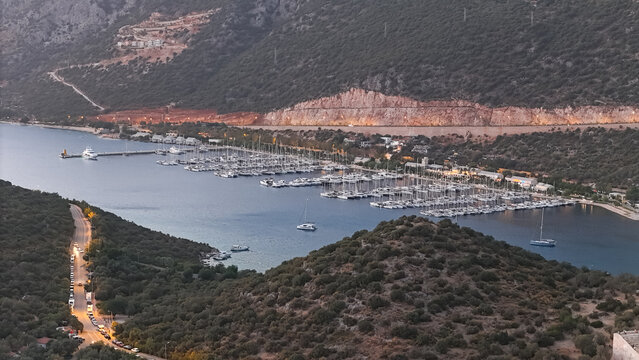Aerial View of Kas Marina at Dusk: Yachts, Breakwater, and Coastal Lights in Turkey.
