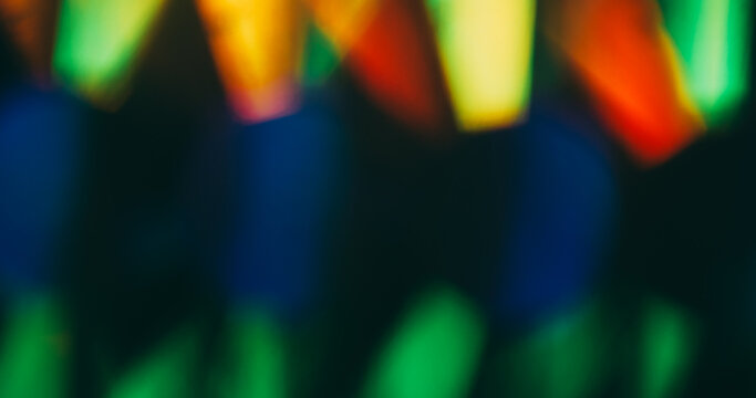Color flare. Blur light rays. Defocused green blue red multicolor shine lens flare glare gleam glow on dark black abstract background.