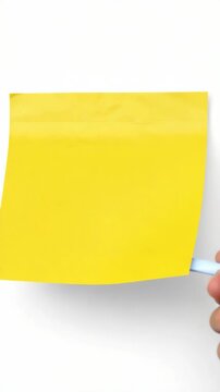 Single yellow post-it note standing upright against a grey surface.
