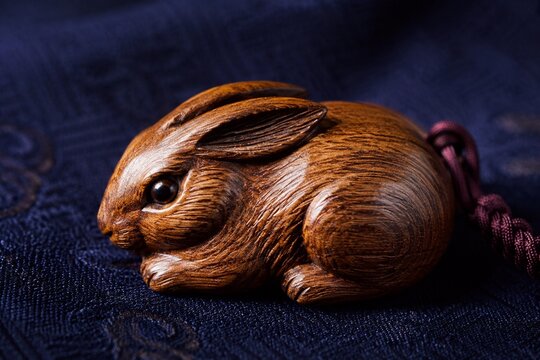Small carved wooden rabbit figure on dark blue silk fabric