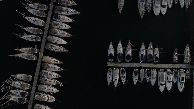 Aerial top down view of yachts docked at marina at night