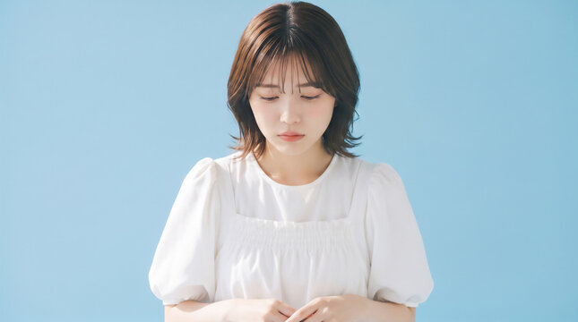 Sad or concerned young Asian woman looking down