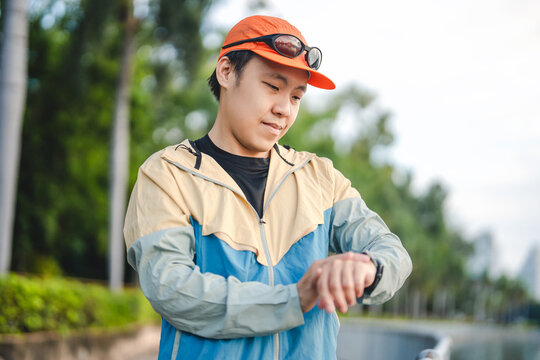 Adult man runner checking smartwatch tracking monitor after workout marathon training