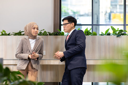 Young business muslim woman and business man colleague talking and meeting discussing at the modern office