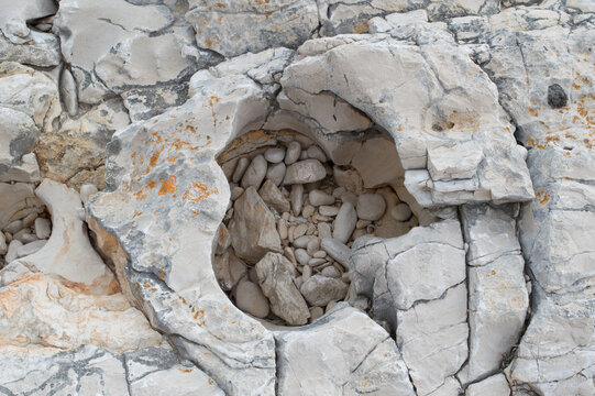 Weathered limestone rocks with orange lichen on Dugi Otok, Adriatic coast, Croatia