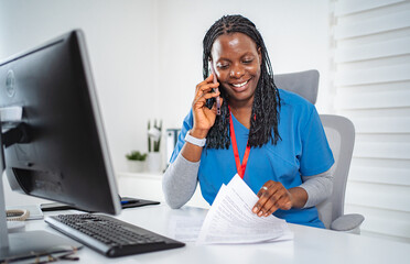 Female nurse communicating on phone while working in office