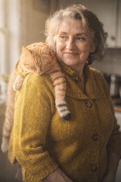 Smiling Senior Woman With Sleeping Ginger Cat on Her Shoulders