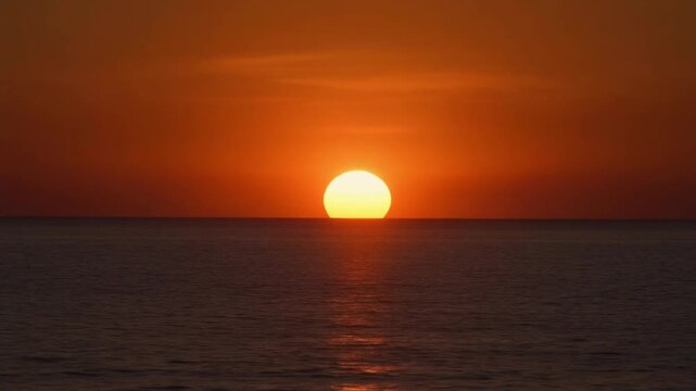 Golden sunset dipping below the horizon at Agia Eleni Beach
