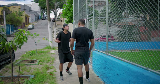 Two Hispanic men outdoors in tense confrontation escalating into argument and physical altercation, intense emotions, anger, conflict, street tension, raw human drama and aggression