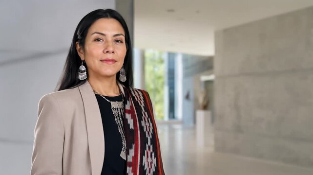 Confident Mapuche businesswoman standing in a modern office with copy space, indigenous leadership and professional career