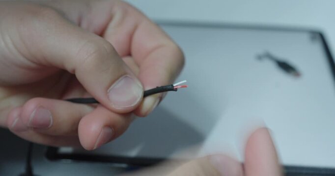 Person touching an exposed wire to test electricity, showing electrical shock danger, safety risks and hazardous situations.