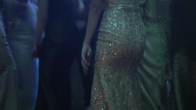 A large crowd of young people dancing to energetic DJ music during an exciting prom night celebration.