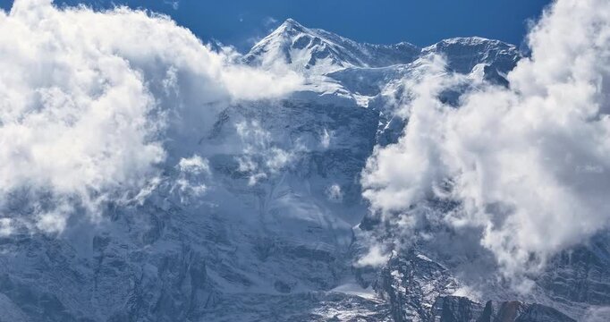 Annapurna Circuit, Manang, Nepal, aerial timelapse shot of clouds sweeping across the snow-covered face of Annapurna II mountain peak, revealing the mythical Yeti face rock formation
