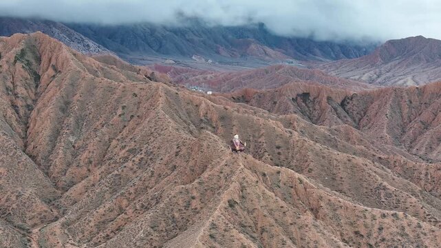 Breathtaking aerial of Sayakbai Karalaev Statue and mountain panorama, Kyrgyzstan