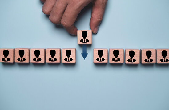 Employee turnover concept with a hand moving a wooden person block, representing staff replacement, workforce transition, recruitment, talent management, human resources and organizational change.