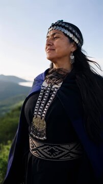 Mapuche woman in traditional dress overlooking Patagonian mountains with copy space