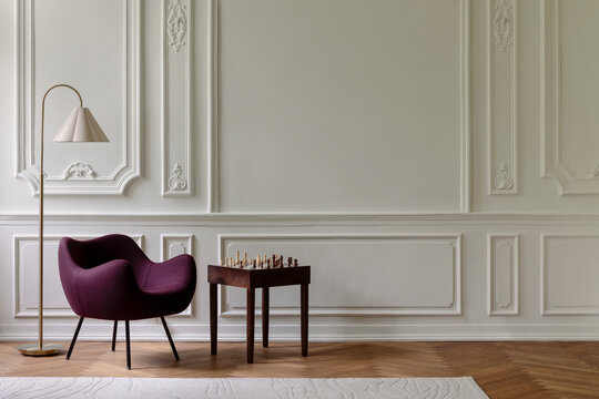 Elegant Living Space with Modern Armchair, Classic Wall Paneling, and Chess Set on Side Table