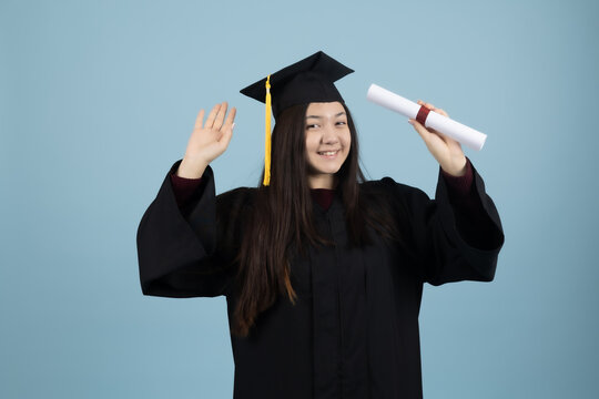 Happy graduate girl holding up her degree diploma celebrating success