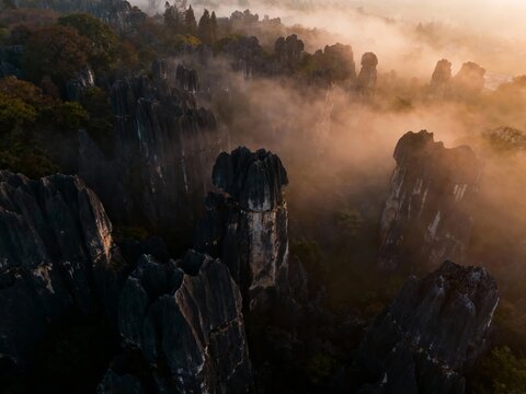 Mist-covered limestone karst formations at sunrise in a mountainous landscape