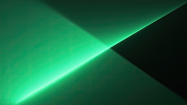 A bright green light cuts through a dark background, creating sharp geometric shapes