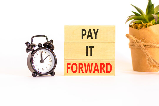Pay it forward words symbol. Concept words Pay it forward on beautiful wooden blocks. Beautiful white background. Black alarm clock. Business and pay it forward concept. Copy space.
