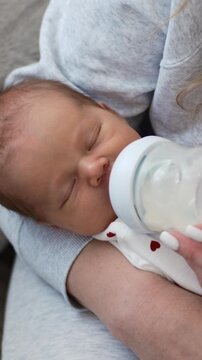Sleepy Newborn Being Fed From A Bottle By Mom In Vertical Video