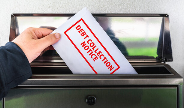 Hand Placing a Debt Collection Notice Envelope into a Mailbox