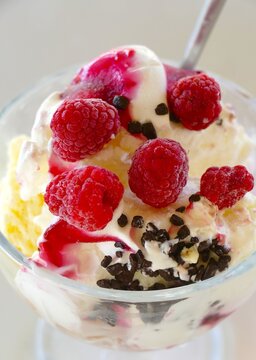 Ice cream in a glass bowl with raspberries and peace of chocolate , summer ice dessert