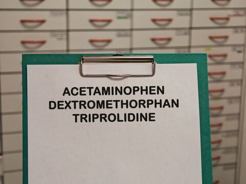 ACETAMINOPHEN DEXTROMETHORPHAN TRIPROLIDINE (PARACETAMOL) analgesic and antipyretic for pain and fever displayed on a clipboard in a pharmacy healthcare concept
