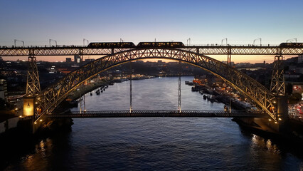 Fototapeta premium Luis I Bridge In Porto Portugal. Aerial View Of Landmark Bridge Showcasing Its Intricate Design . Sunset Sky Downtown Cityscape. Sunset Outdoors Downtown. Porto Portugal.