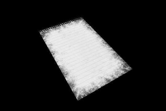 Notebook paper page isolated on black JPEG background, lying on a shelf.