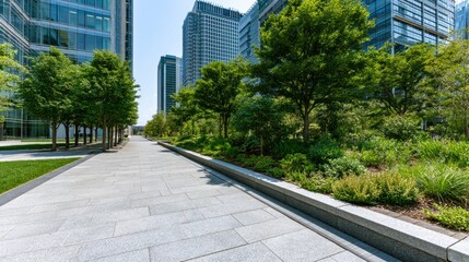 Fototapeta premium Modern urban park pathway with trees, lush greenery, and glass buildings