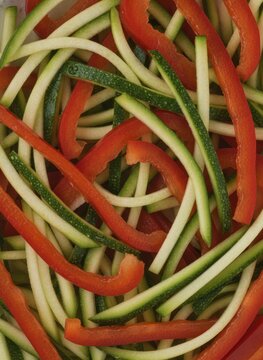 Spiralized Zucchini and Red Bell Pepper Strips Top View Background