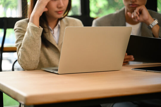 Cropped of an Asian Business Professionals Working Together on Laptops at Wooden Office Table in Modern Workspace