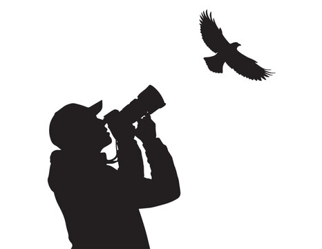 Silhouette of a photographer with camera and flying bird on white background