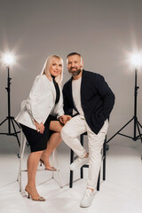 Obraz premium A man and a woman in strict clothes pose against the background in the studio
