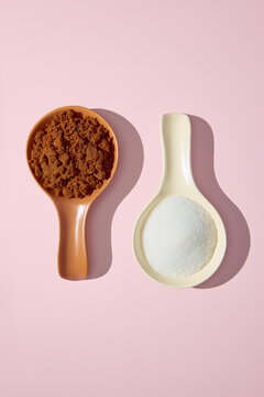 Muscovado sugar and white granulated sugar side by side on pink background