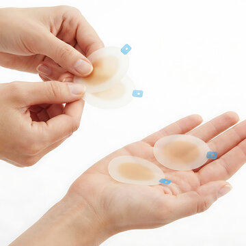 Hydrocolloid acne patches held by hands on white background fingers
