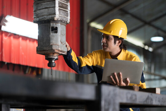 Manufacturing industry and factories. Heavy industry machine. Maintenance or repair industrial machine. Asian male factory engineer inspecting or maintenance vertical drilling machine in factory