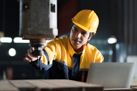 Manufacturing industry and factories. Heavy industry machine. Maintenance or repair industrial machine. Asian male factory engineer inspecting or maintenance vertical drilling machine in factory