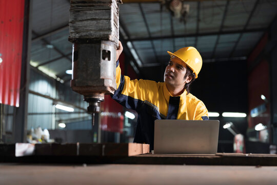 Manufacturing industry and factories. Heavy industry machine. Maintenance or repair industrial machine. Asian male factory engineer inspecting or maintenance vertical drilling machine in factory